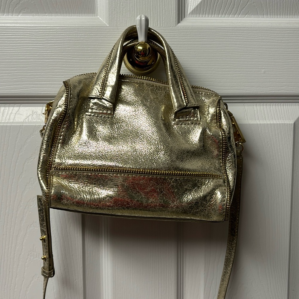 Gold Botkier bag with zipper detail and cross body strap